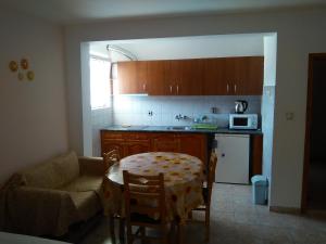 a kitchen with a table and a chair and a microwave at Guest House D. Bogdanova in Obzor