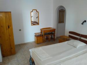 a bedroom with a bed and a table and a mirror at Guest House D. Bogdanova in Obzor