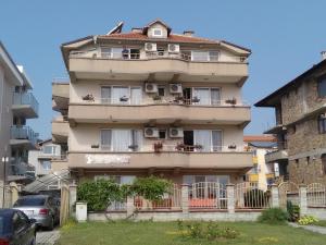 a tall apartment building with people on the balcony at Guest House D. Bogdanova in Obzor
