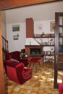 a living room with a red couch and a fireplace at Villa Punta in Okrug Donji