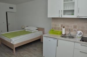 a small kitchen with a bed and a sink at Apartments La Dolce Vita in Herceg-Novi