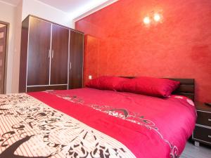 ein rotes Schlafzimmer mit einem großen Bett und einer roten Wand in der Unterkunft Living Room New in Tarnów
