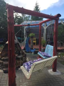 a swing set with two chairs in a backyard at Auberge Internationale Le Tangon in Sept-Îles