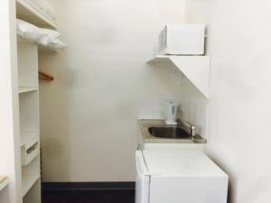 a white bathroom with a white sink and white cabinets at Springsure Overlander Motel in Springsure