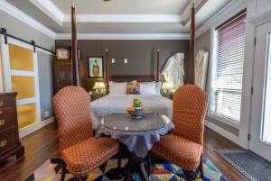 a bedroom with a bed with a table and chairs at Brookside Inn Boutique Hotel in Abbotsford