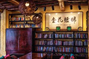 une chambre avec de nombreuses étagères remplies de dvds dans l'établissement Guixu Huatang Homestay, à Qinhuangdao