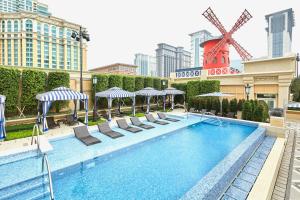 a swimming pool with lounge chairs and a windmill at The Parisian Macao in Macau