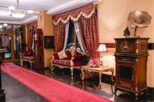 a living room with red furniture and a red rug at Villa Park Hotel Strumica in Strumica