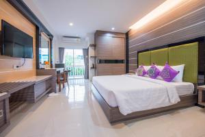 a bedroom with a large bed and a flat screen tv at U Duay Gan Garden Home in Ubon Ratchathani