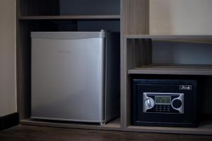a refrigerator and a microwave in a shelf at Gurney Lodge in George Town