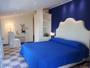 niebiesko-biała sypialnia z łóżkiem i biurkiem w obiekcie Hotel La Vue d'Or w Sorrento +37 zdjęć