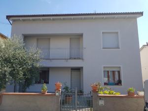 a white house with a balcony and potted plants at B&B Buscemi in Pistoia