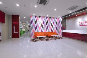 a lobby with two orange benches in a store at favehotel Sorong in Sorong