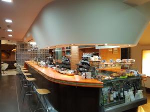 a restaurant with a long bar with a lot of food at Hostal El Aparcamiento in Luarca