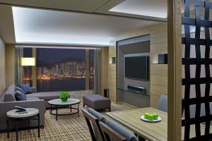a living room with a couch and a table at New World Millennium Hong Kong Hotel in Hong Kong
