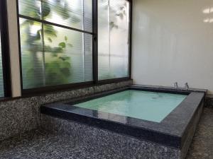 a swimming pool in a room with a window at Ryokan Matsukaze in Matsumoto