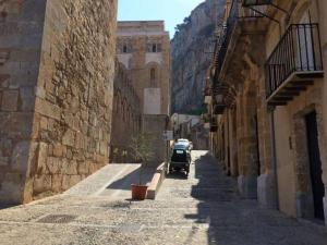 une voiture est garée dans une rue dans une ruelle dans l'établissement Cefalù Cathedral Palace, à Cefalù