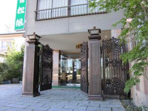 einen Eingang zu einem Gebäude mit einem Eisentor in der Unterkunft Ryokan Matsukaze in Matsumoto