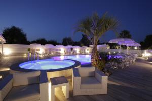 a swimming pool at night with chairs and umbrellas at Garden Hotel Ripa in Vieste