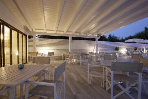 a patio with tables and chairs under a pergola at Garden Hotel Ripa in Vieste