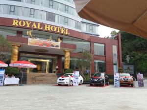 a hotel with two cars parked in front of it at Lao Cai Royal Hotel in Lao Cai