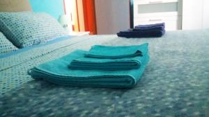 3 asciugamani posti sopra un letto di Casa Roby 120 mt Beach a Fontane Bianche