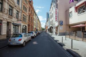 una calle de la ciudad con coches aparcados en la calle en 18Arts Hotel - Living in a Gallery! en Colonia