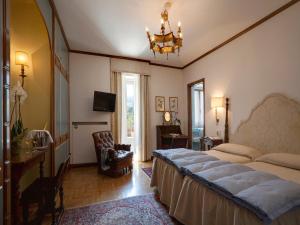 a bedroom with a large bed and a chandelier at Hotel De La Poste in Cortina dʼAmpezzo