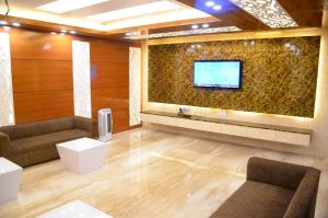 a living room with a tv on a wall at Platinum Palace in Gurgaon