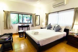 1 dormitorio con cama, mesa y ventana en YK Art House, en Phnom Penh