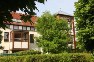 un edificio con un árbol delante de él en Wohnen auf Zeit am Golfplatz Motzen, en Motzen