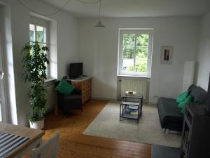 a living room with a couch and a tv at Das Alte Forsthaus in Geisenheim