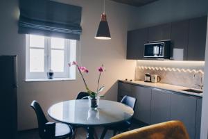 a kitchen with a table with a vase of flowers on it at Sally Port Suites in Valletta