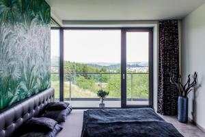 a bedroom with a bed and a large window at Amazing Apartments in Brno
