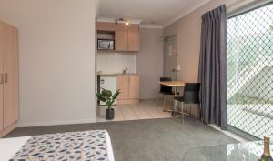 a living room with a kitchen and a table with chairs at Pacific Coast Motel in Gold Coast