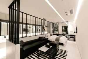 a bedroom with a bed and a black couch at Ischia Hotel in Yongin