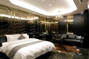 1 dormitorio con cama, sofá y lámparas de araña en Ischia Hotel en Yongin