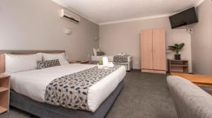 a bedroom with a large bed and a television at Pacific Coast Motel in Gold Coast