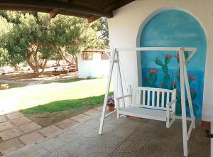 a white porch swing in front of a house at bolinajazz in Lampedusa