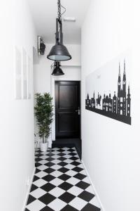 a hallway with a black door and a checkered floor at LOOX serviced apartments Hatzova in Zagreb