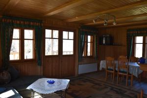 a living room with a table and chairs and windows at Bērziņi in Vitrupe