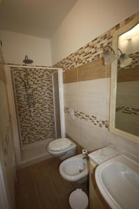 La salle de bains est pourvue de toilettes, d'un lavabo et d'une douche. dans l'établissement La Rosa dei Venti, à Zambrone
