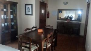 a dining room with a table and chairs and a mirror at Apartamentos Rurales Casas de los Maestros in Talarrubias