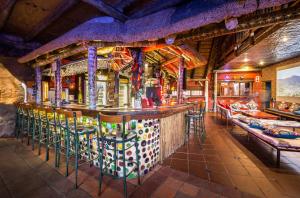 een bar in een restaurant met krukken bij Amphitheatre Backpackers Lodge in Ethels Drive