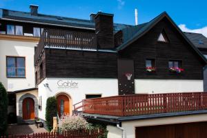 ein schwarzweißes Haus mit einem Balkon in der Unterkunft Appartements Gahler - Kurort Oberwiesenthal in Kurort Oberwiesenthal