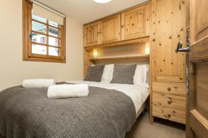 シャモニー・モンブランにあるApartment Mazot Loppeのベッドルーム1室(ベッド1台付)、木製キャビネットが備わります。