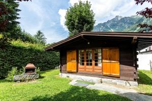 una piccola cabina in erba con montagne sullo sfondo di Apartment Mazot Loppe a Chamonix-Mont-Blanc