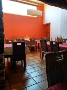 a dining room with red walls and tables and chairs at Veniata in San Pedro de las Herrerías