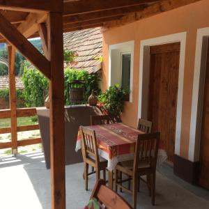 a table and chairs on the porch of a house at Liliom Vendégház in Bakonybél