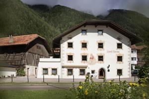 ein großes weißes Gebäude vor einem Berg in der Unterkunft Wonga Apartments in Gais